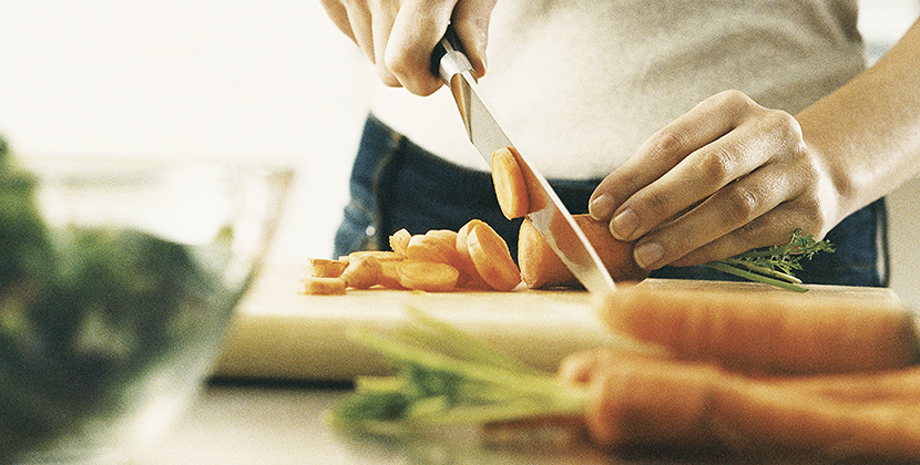 mid section view of a young woman cutting carrot