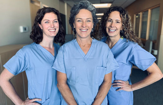 3 smiling females in scrubs