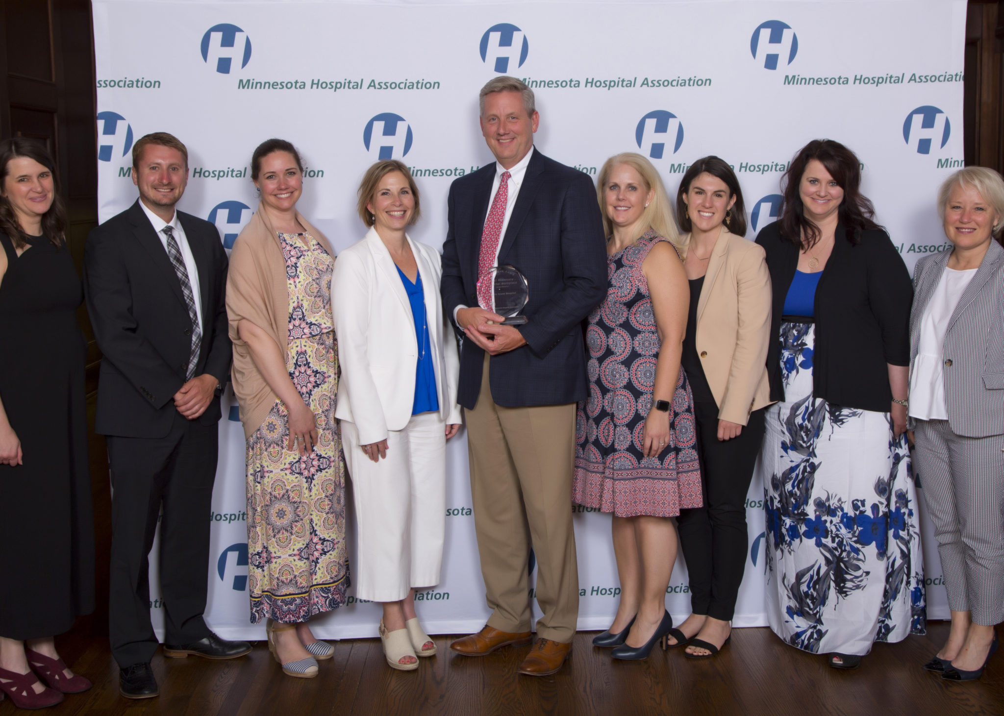 Group of hospital leaders smiling with award