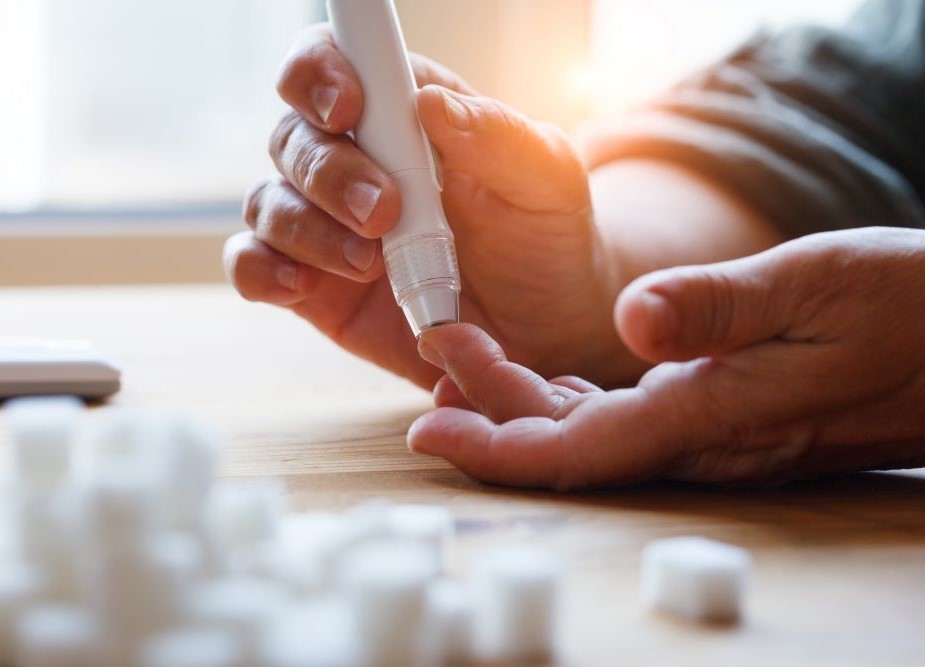 Woman hands using lancet on finger to check blood sugar level