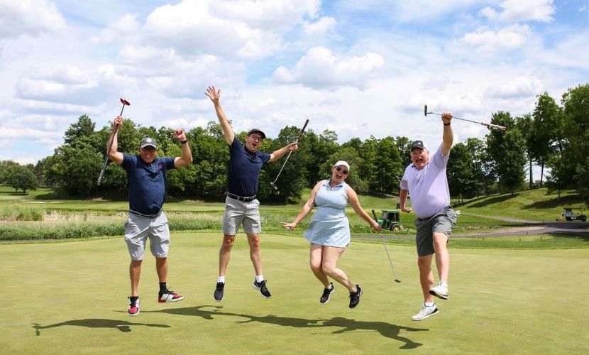 Four golfers jumping in the air at the 2026 Foundation golf tournament