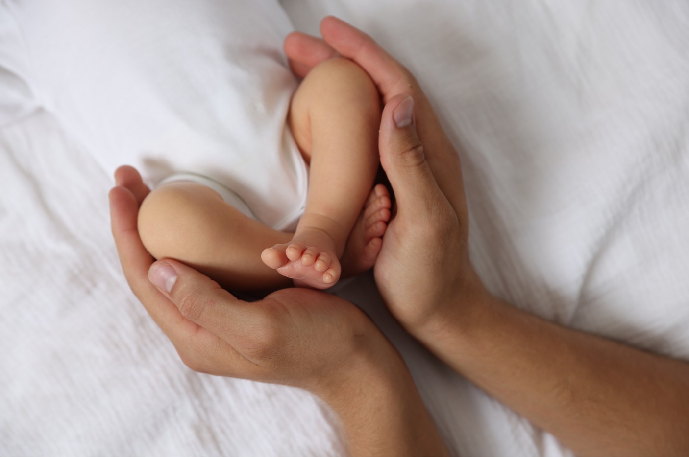 Mother's hands cradling baby's feet