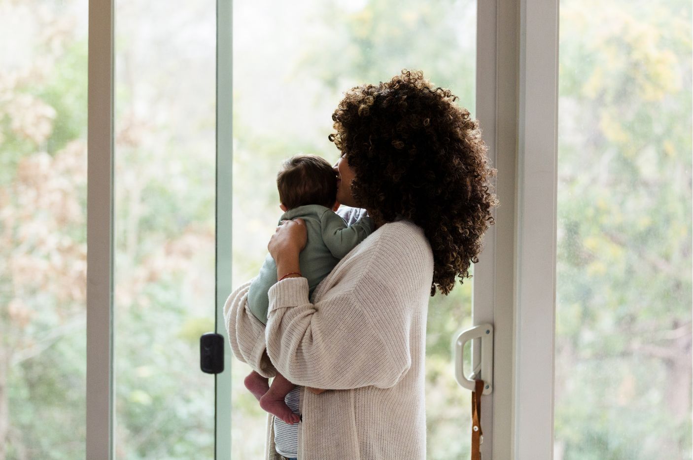 Mother holding newborn looking outside