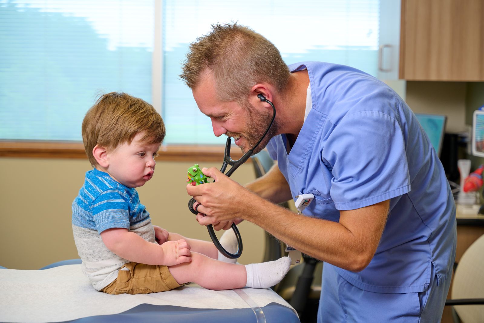 Pediatric care provider visiting with toddler patient
